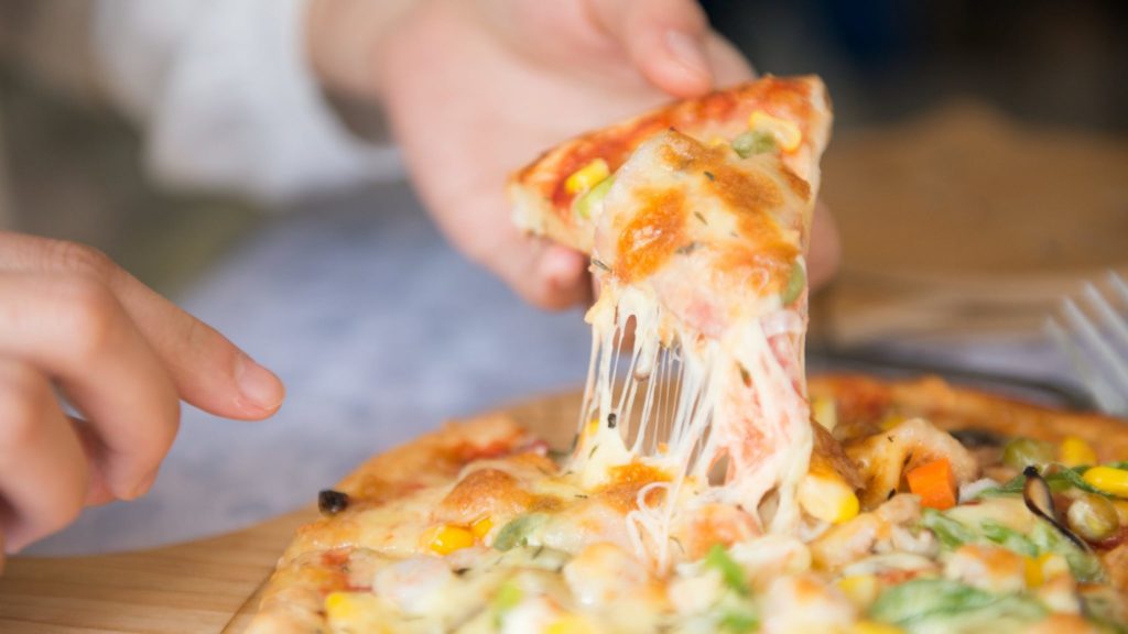 Person picking slice of pizza