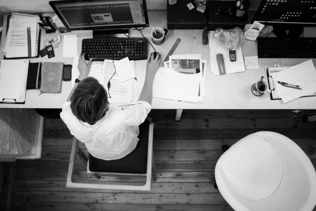 Man with messy desk working on computer