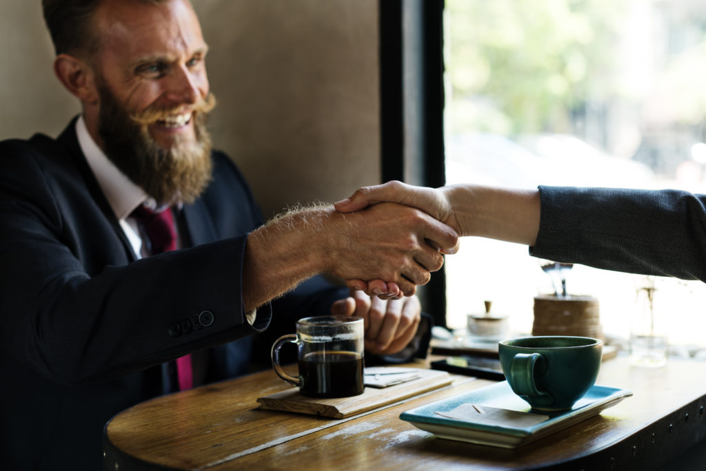 Man smiling while shaking hands