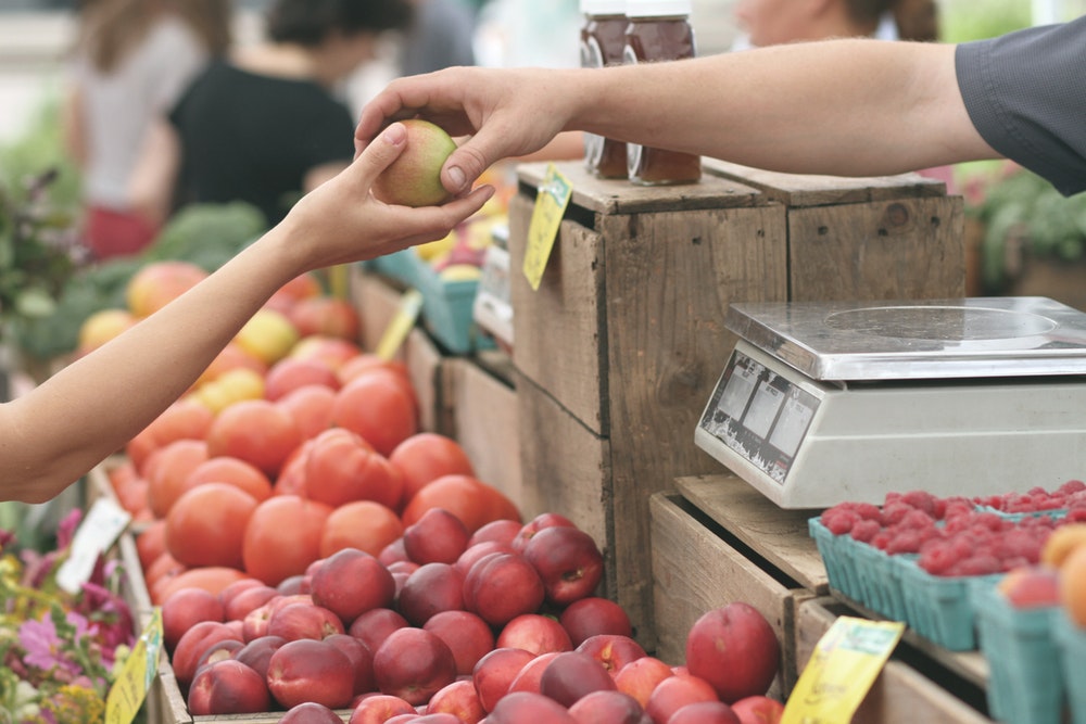 Person handing an apple to another person