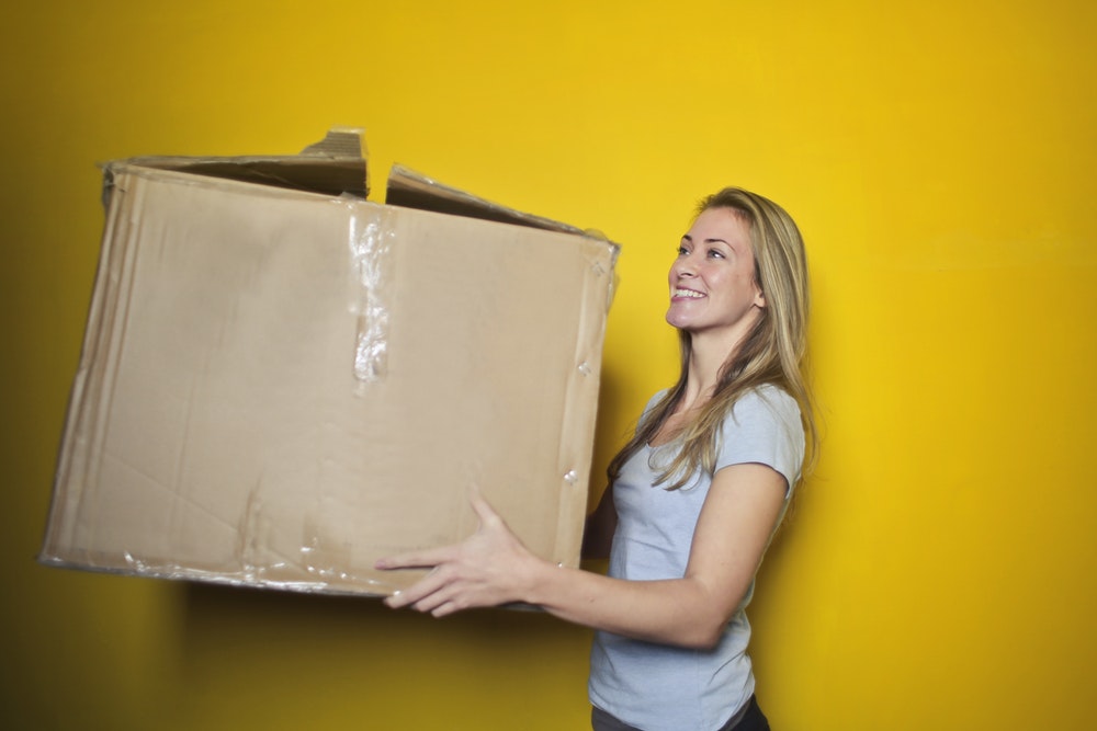 Smiling woman carrying a box