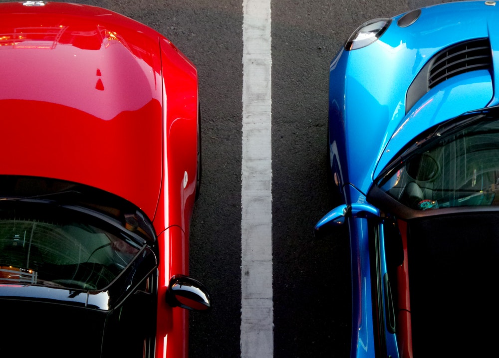 Red and blue cars parked in a parking space