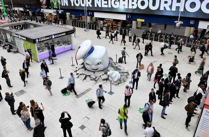 Monster bursting out of the floor while people walk around and take photos