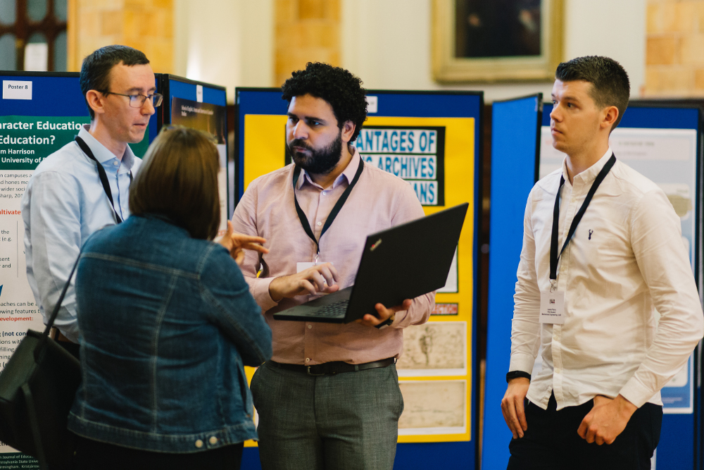 Delegates talking to man with a laptop infront of an exhibition stand