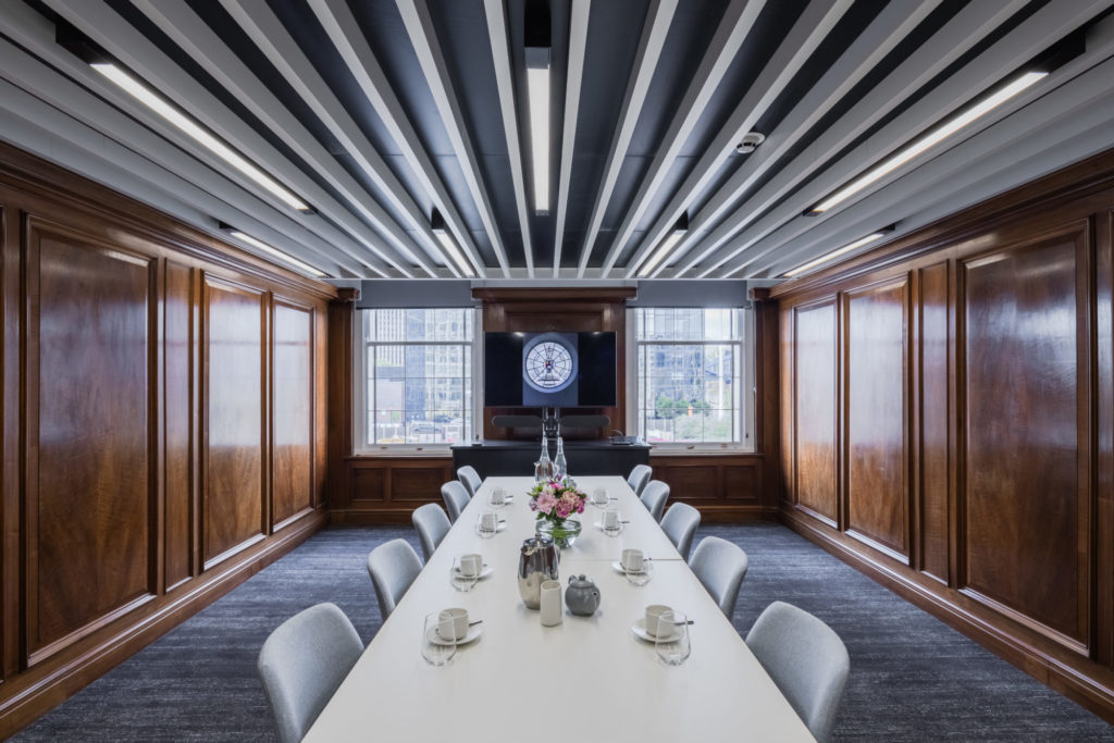 Boardroom at The Exchange: white table and contemporary chairs as main focus, leading to stained glass window. 
