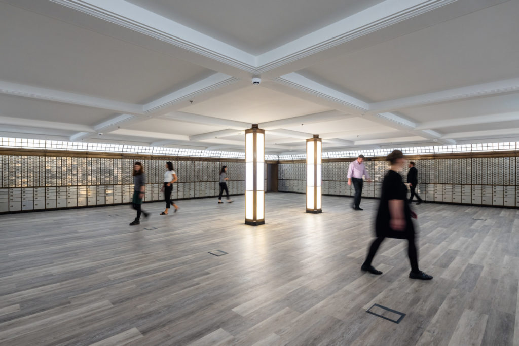 People walking around the Vaults at The Exchange, an open underground space with original bank vaults.