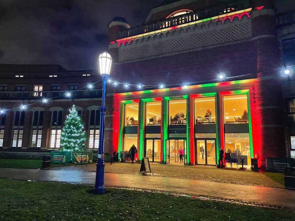 Green and red lights outside the Bramall. Outside lit with Christmas tree and lights.