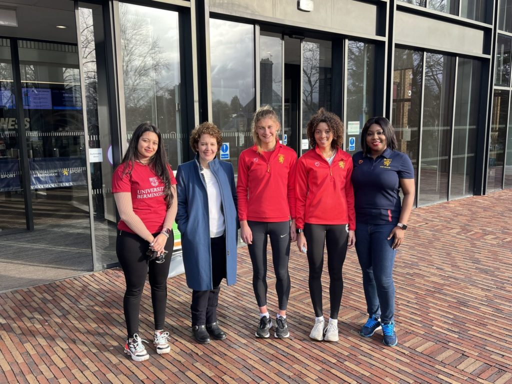 Jo Lomas stands between UB Sport students