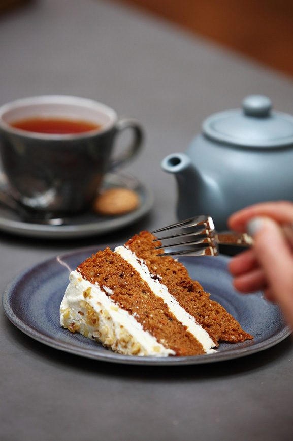 Carrot cake next to a cup of tea