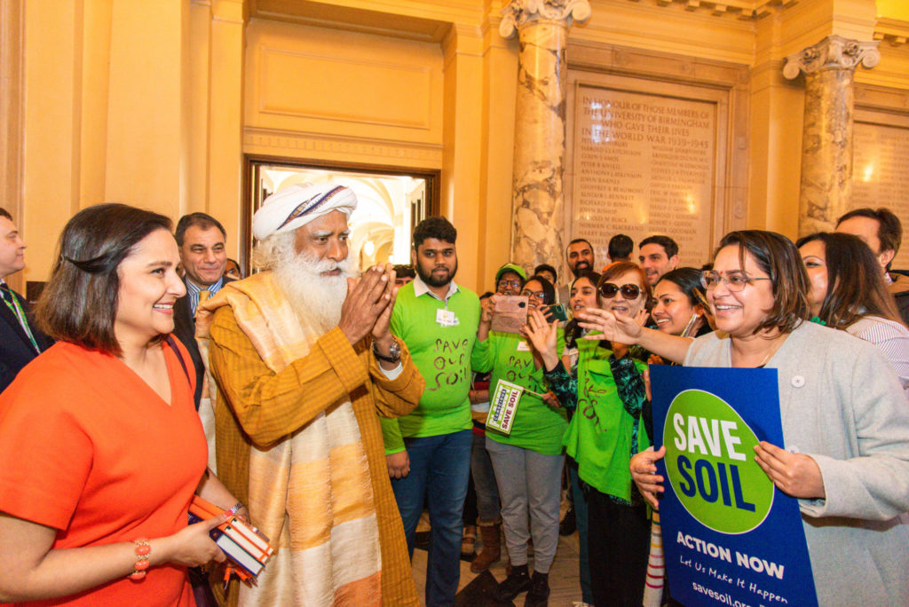 Sadhguru walks amongst guests, and gestures with his hands clasped in thanks