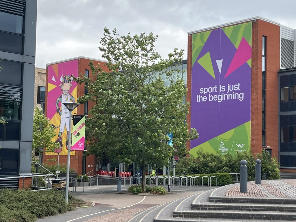 University buildings wrapped in bright Commonwealth Games branding.