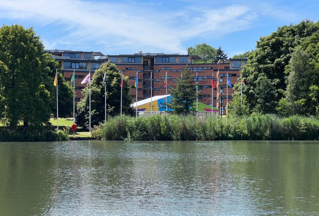 The Vale Village lake with Commonwealth flags surrounding it.