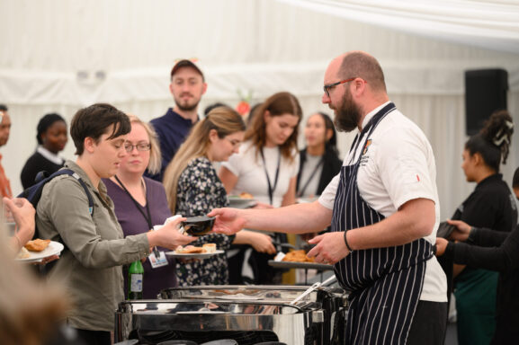 A chef handing over a plate to a delegate