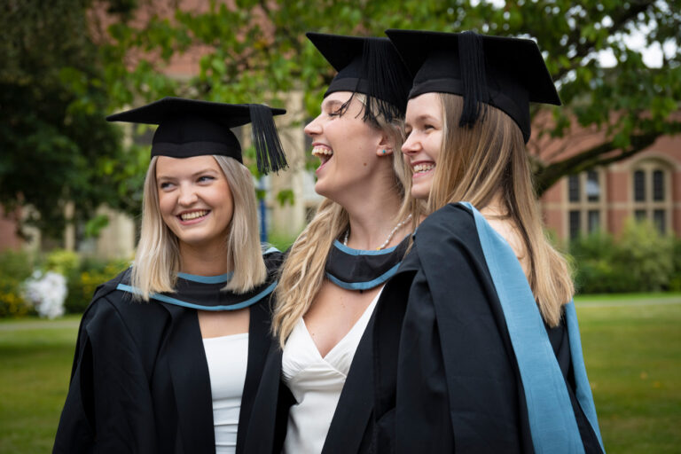 Three graduats smiling