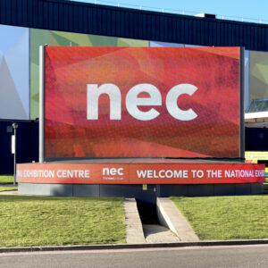 A large digital screen outside the NEC